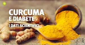 Immagine di curcuma in polvere posizionata sopra un tavolo e un cucchiaio di legno